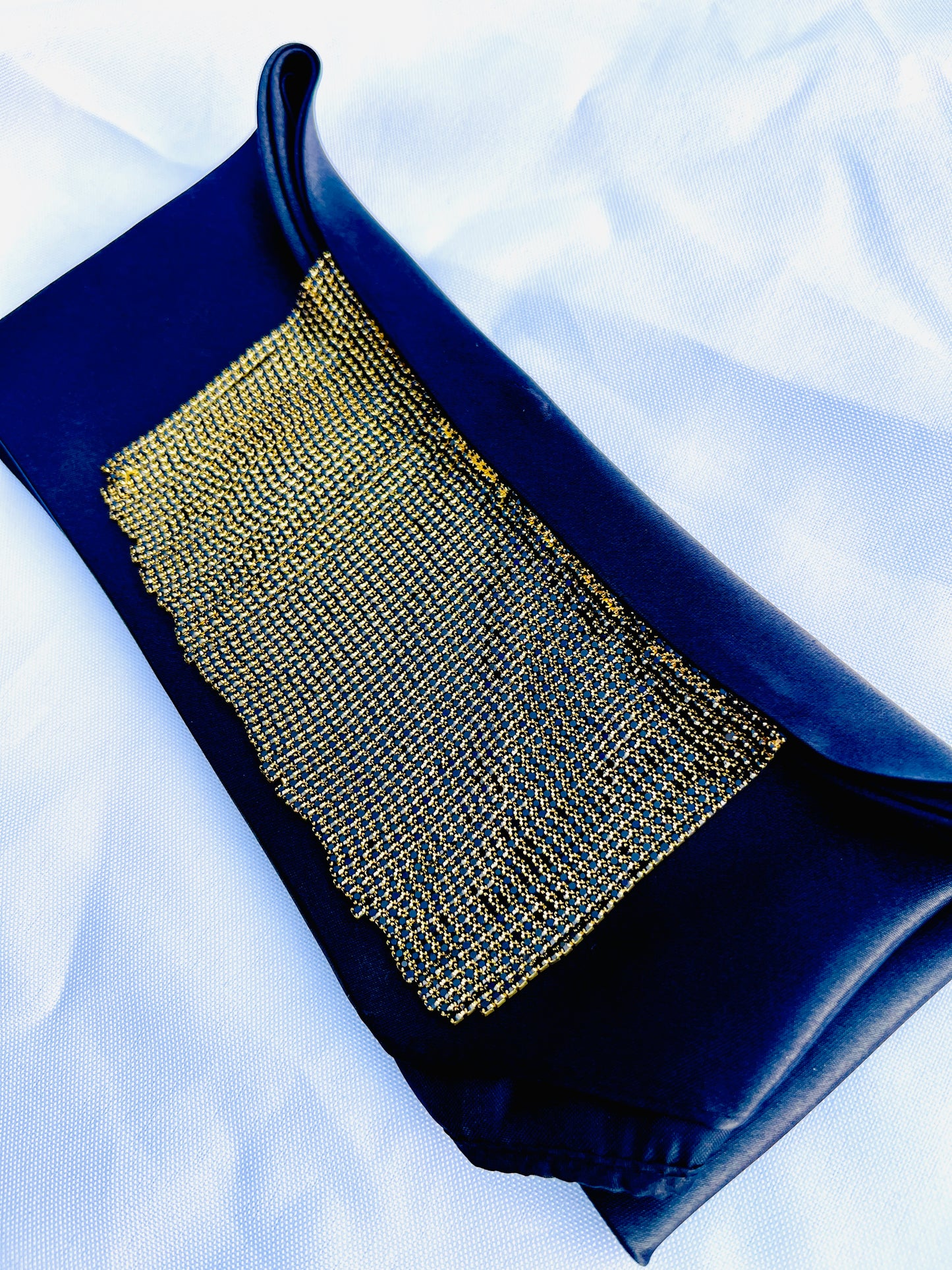 Minerva black satin bandana bang with gold fringe laid flat.