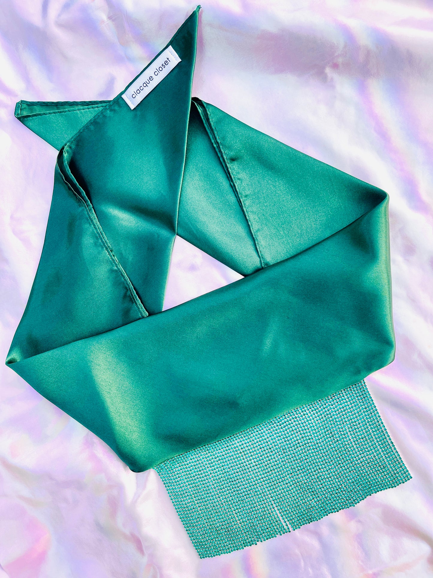 Freya handmade green satin bandana bang with turquoise fringe laid flat on iridescent background