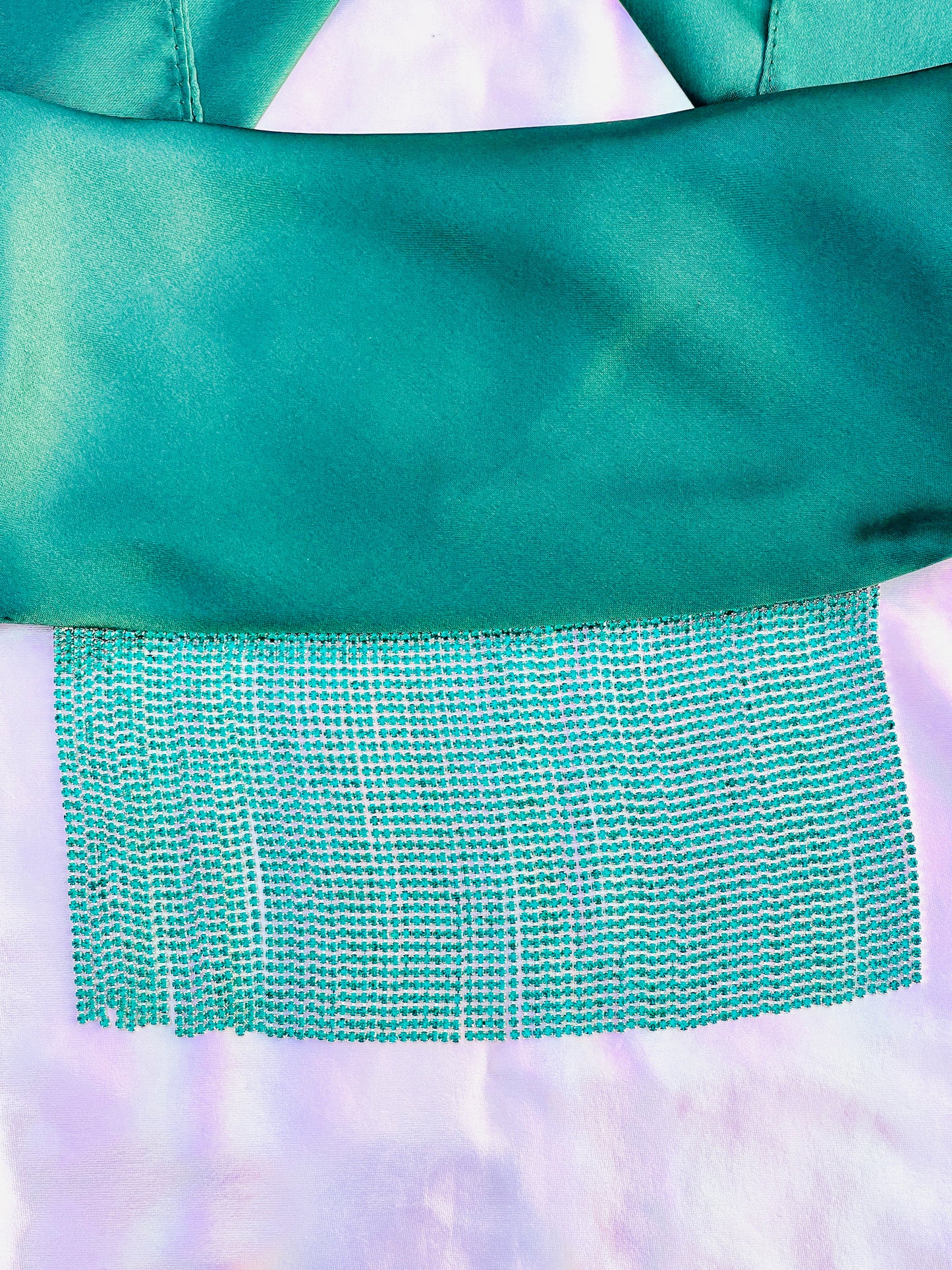 Freya handmade green satin bandana bang with turquoise fringe laid flat on iridescent background