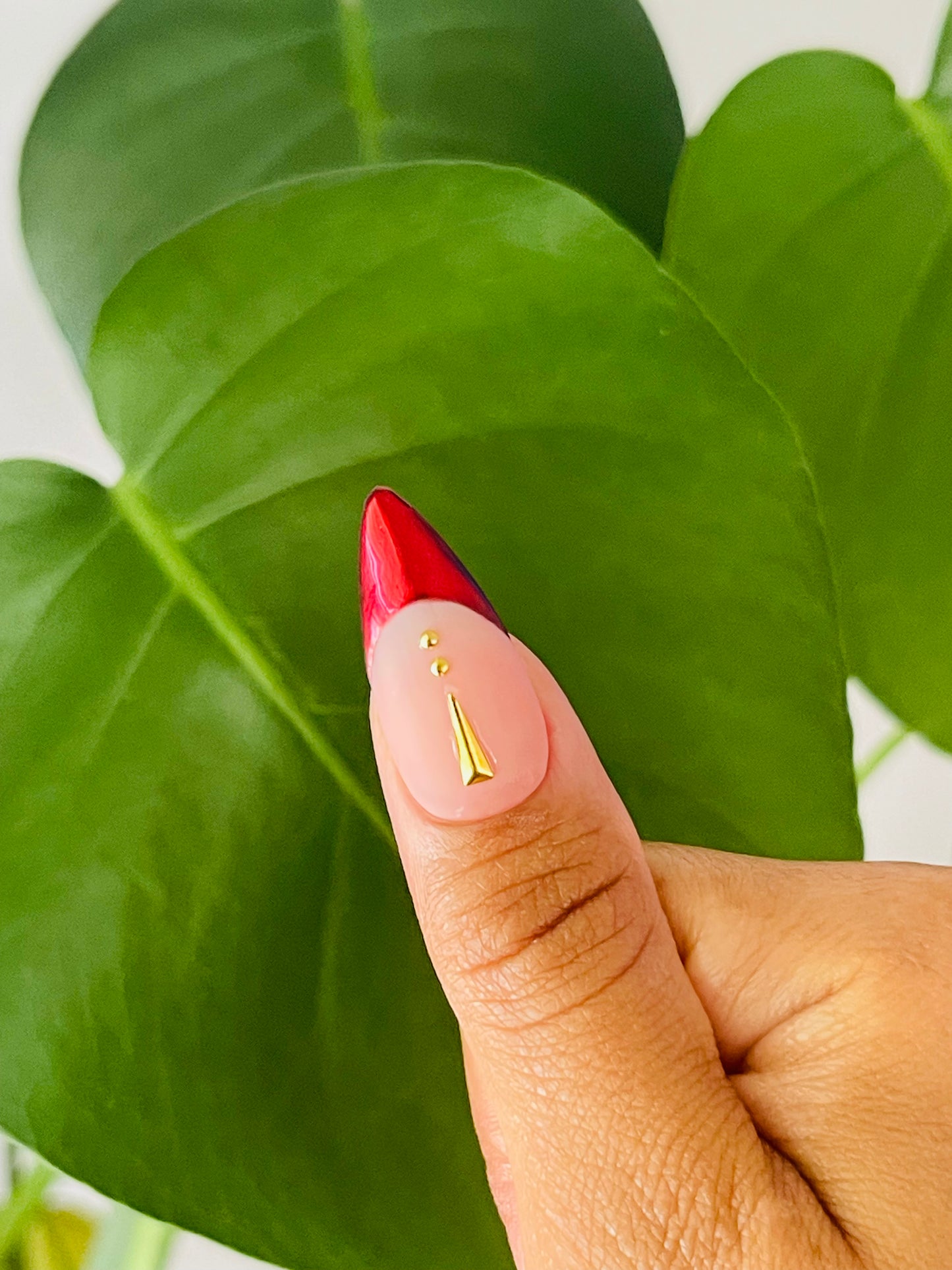 Medium-length stiletto nails featuring a classic French tip design with a modern twist, incorporating red chrome and gold accents for a striking and luxurious look.