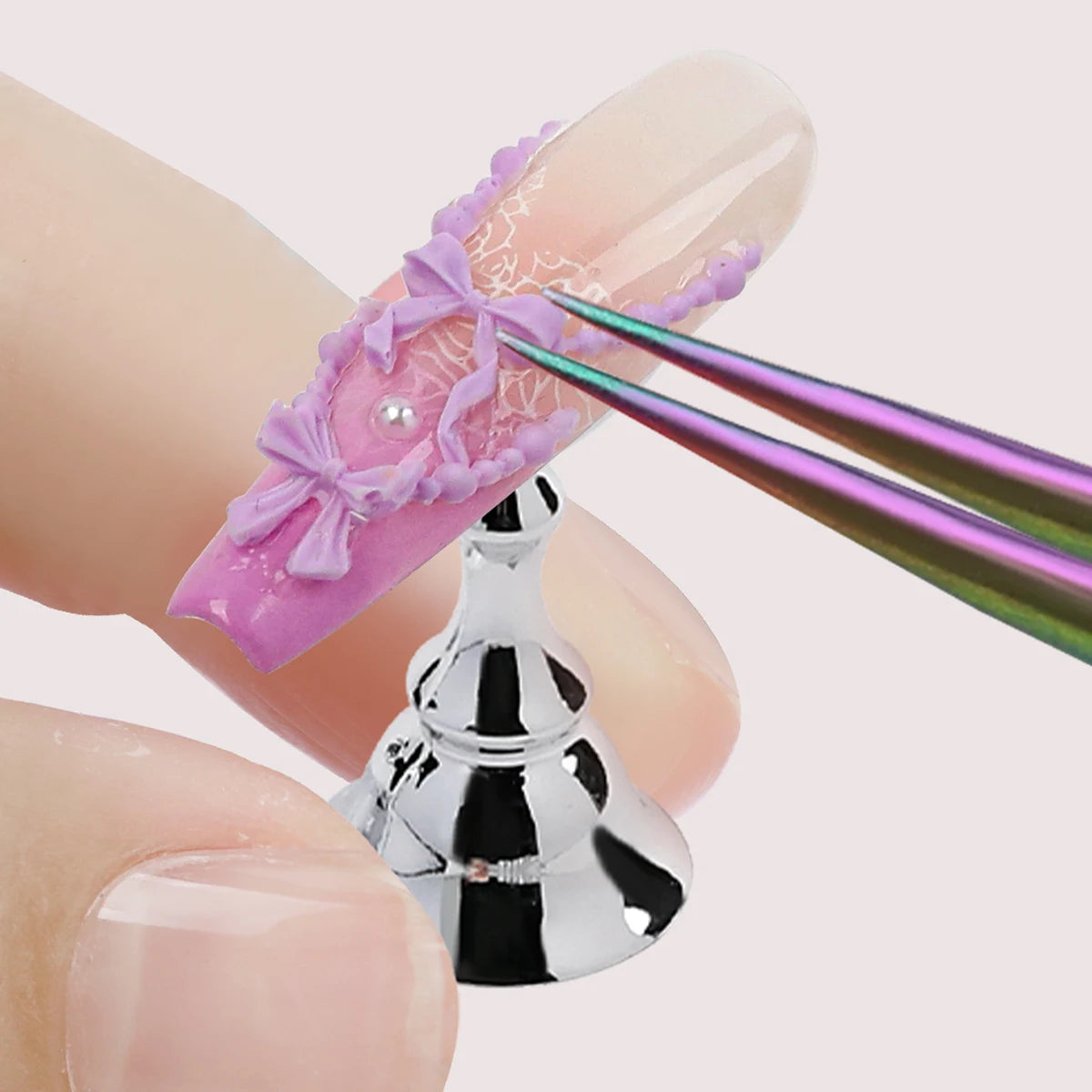 Close-up of a hand with a decorative nail design and a silver bell charm.
