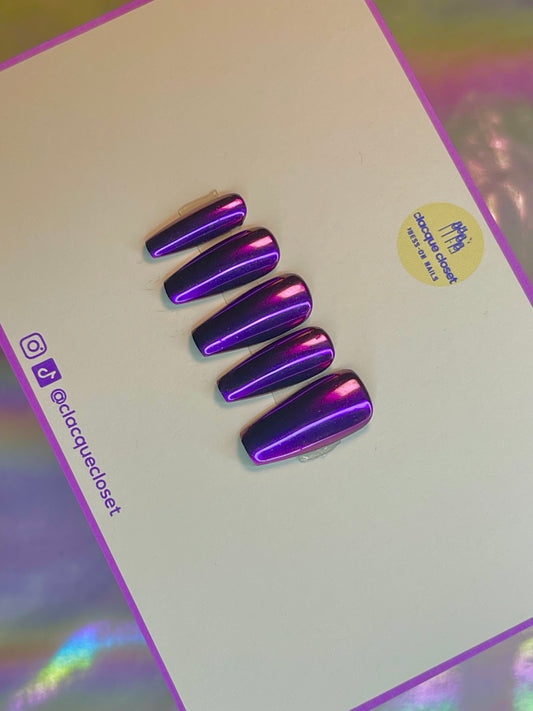 A set of press-on nails featuring a luminous purple chrome finish, giving off a vibrant, iridescent sheen that changes under different lighting conditions.