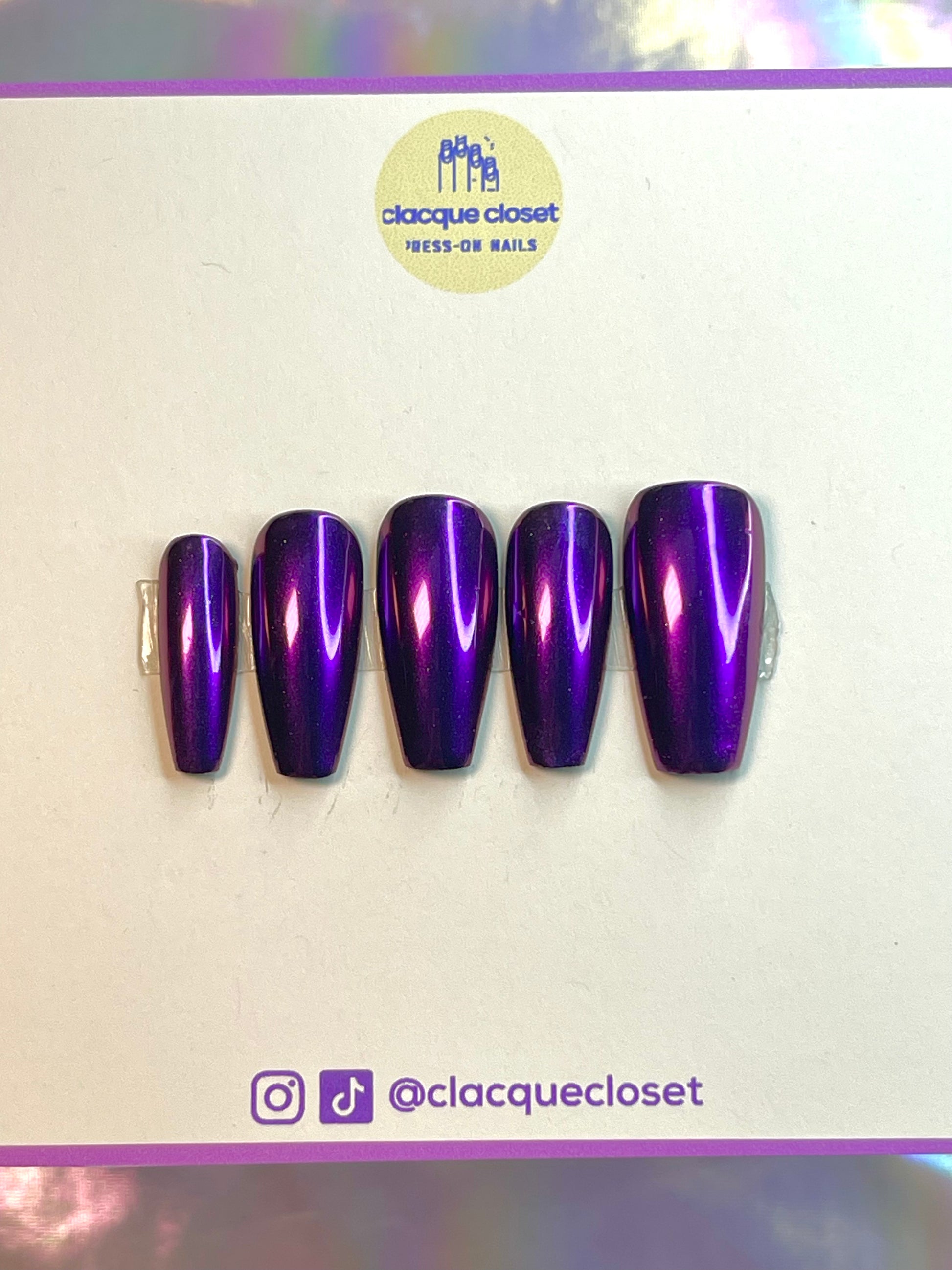 A set of press-on nails featuring a luminous purple chrome finish, giving off a vibrant, iridescent sheen that changes under different lighting conditions.