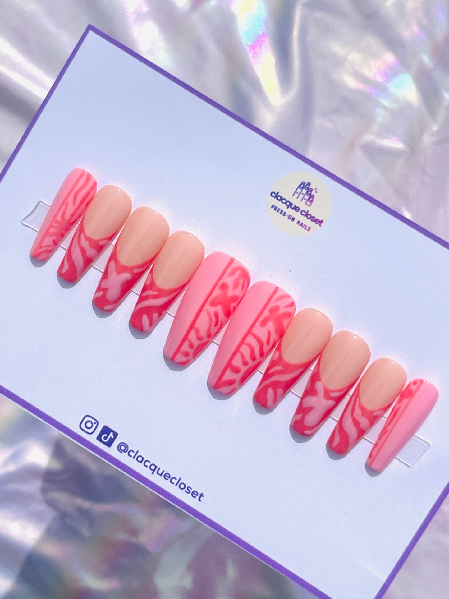 Long coffin-shaped nails featuring a unique blend of pink and red hues, decorated with abstract art designs for a modern and artistic flair.