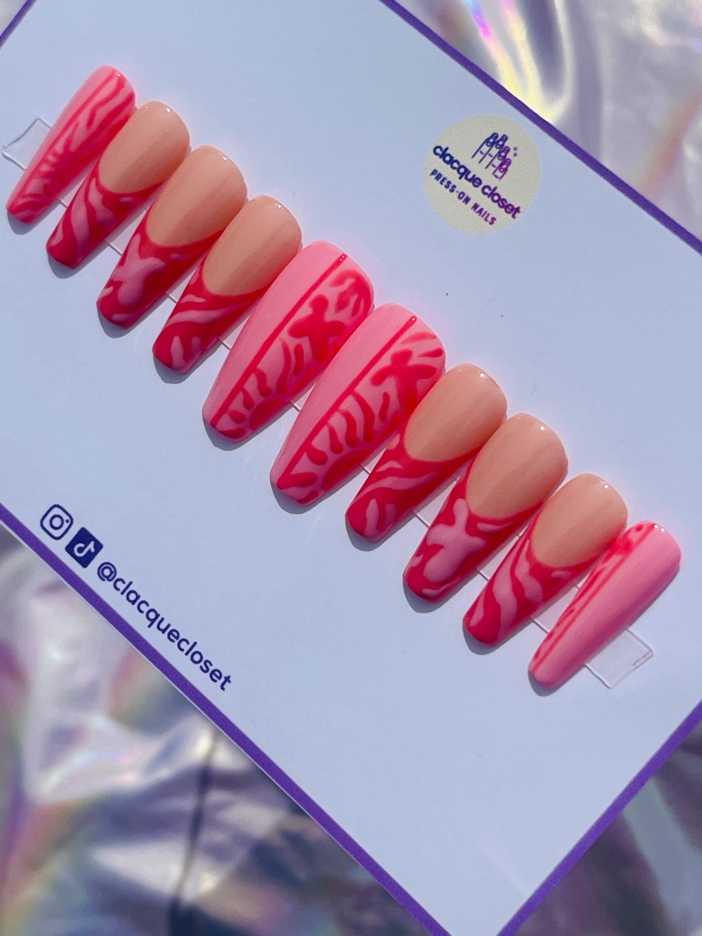 Long coffin-shaped nails featuring a unique blend of pink and red hues, decorated with abstract art designs for a modern and artistic flair.