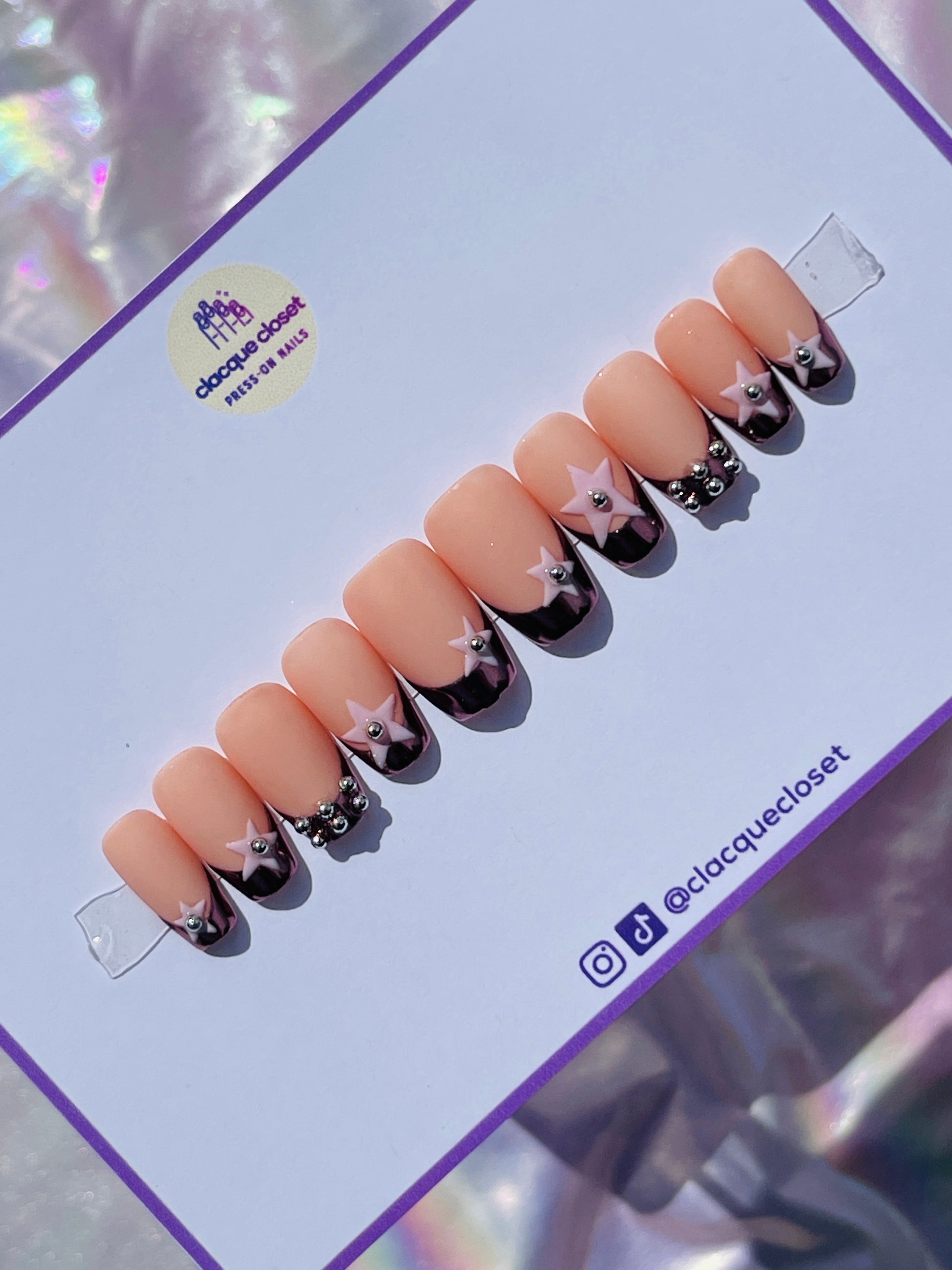 Medium-length coffin-shaped nails with a luxurious rose gold chrome French tip, embellished with pink stars and silver metal balls for a chic and elegant look.