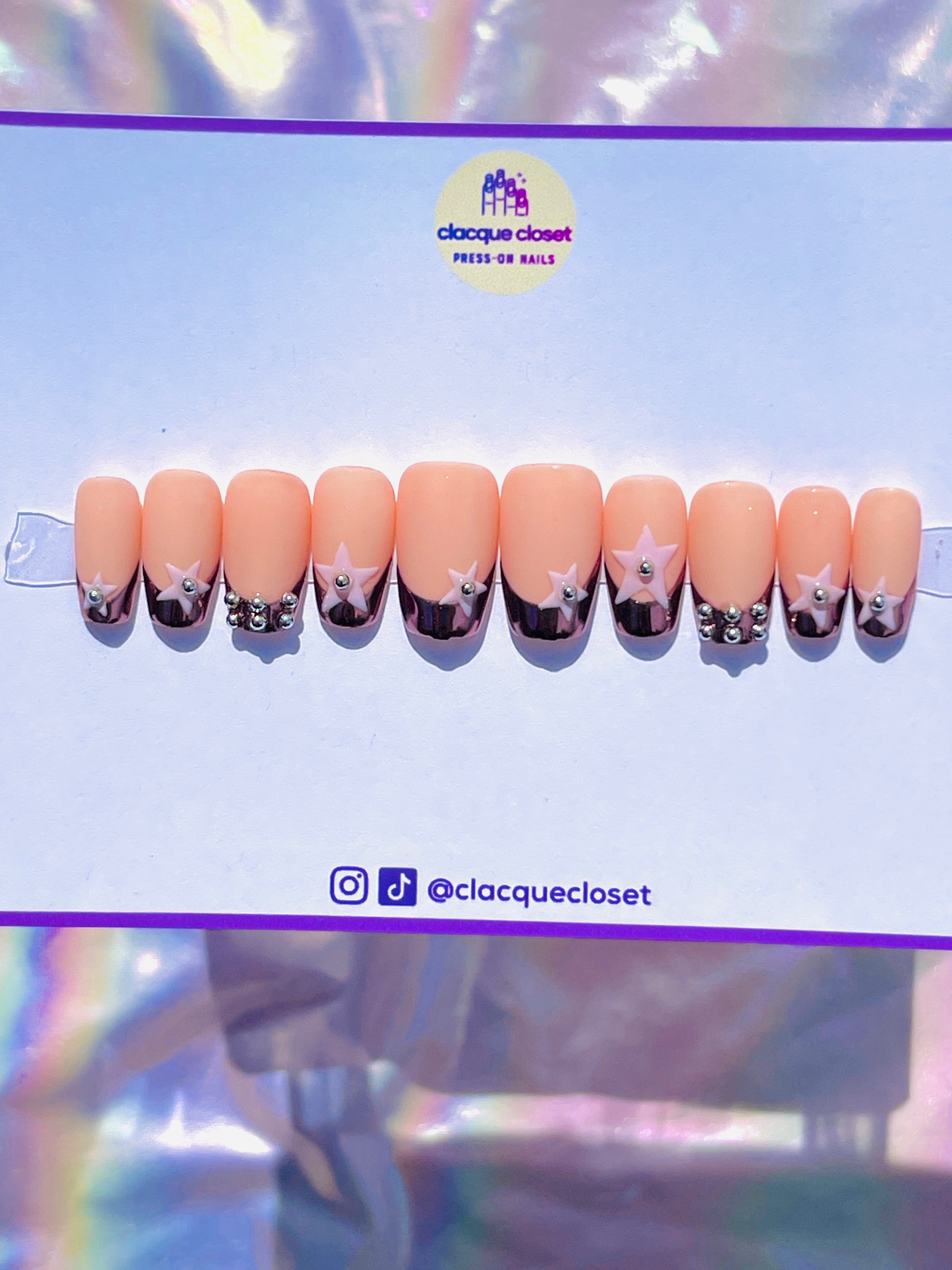 Medium-length coffin-shaped nails with a luxurious rose gold chrome French tip, embellished with pink stars and silver metal balls for a chic and elegant look.