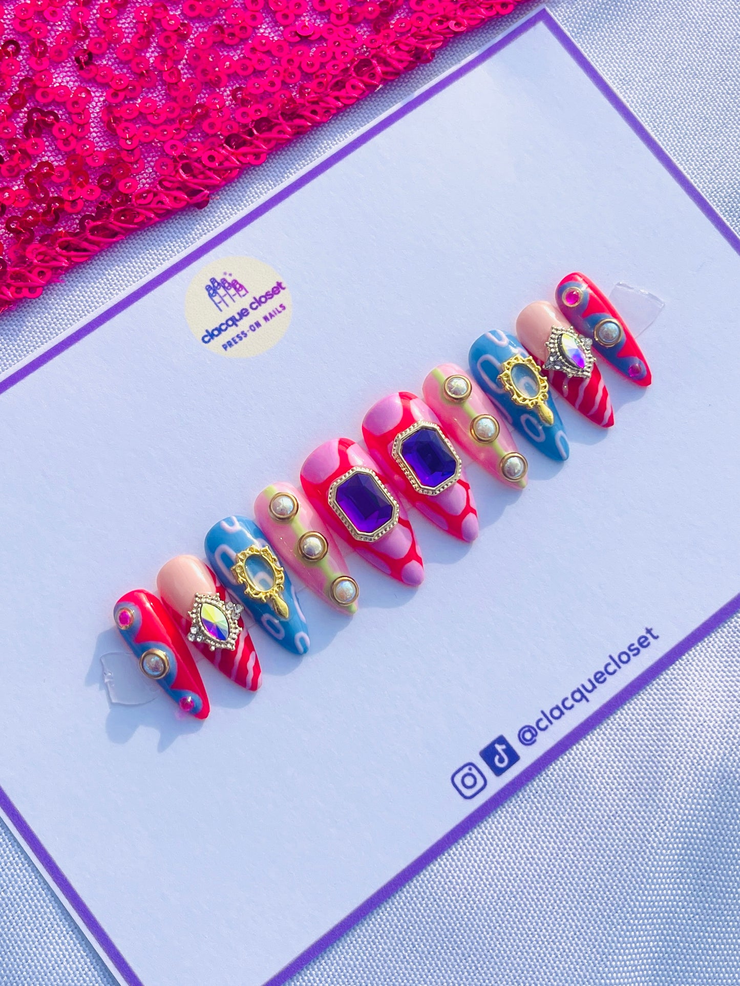 Medium-length stiletto nails featuring an extravagant set filled with various charms and abstract art designs, embodying a bold and artistic expression.