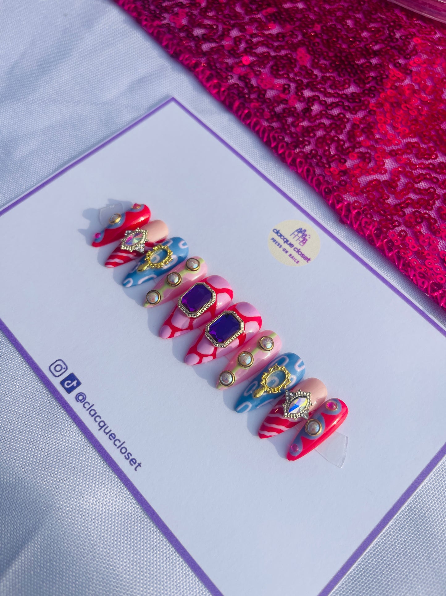 Medium-length stiletto nails featuring an extravagant set filled with various charms and abstract art designs, embodying a bold and artistic expression.