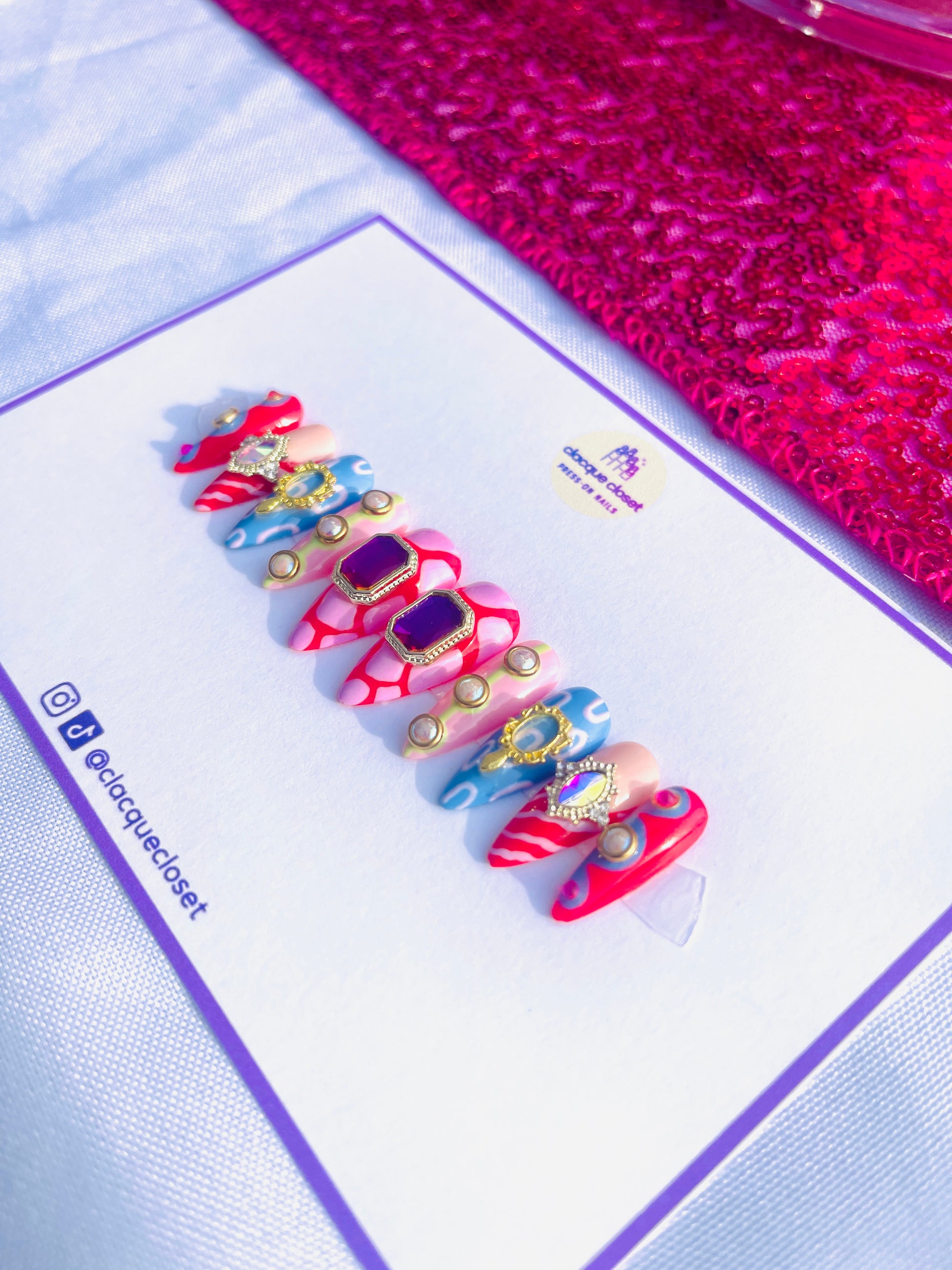 Medium-length stiletto nails featuring an extravagant set filled with various charms and abstract art designs, embodying a bold and artistic expression.