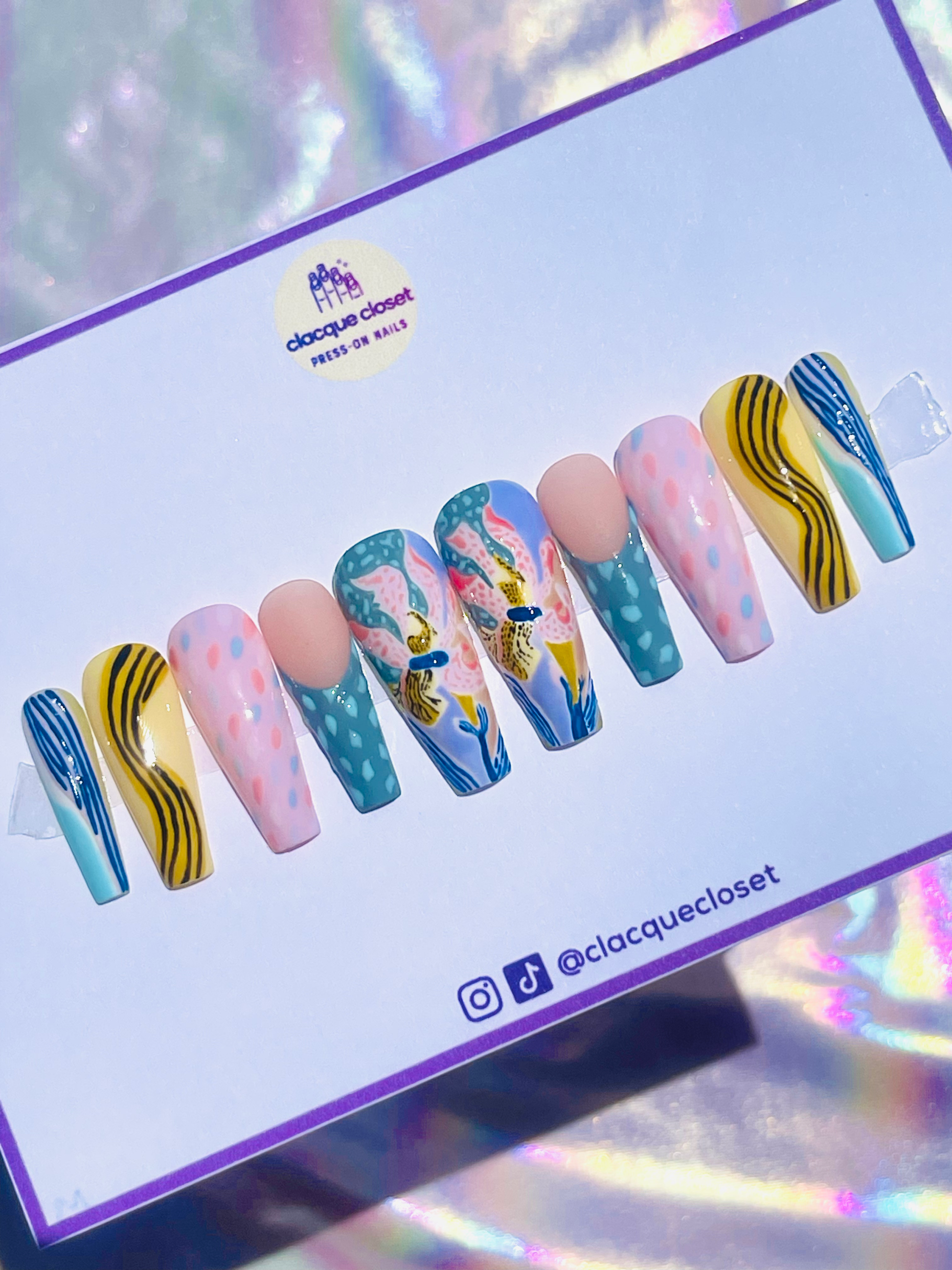 Long coffin-shaped press-on nails featuring a floral design with various patterns in pastel colors for a delicate and vibrant look.