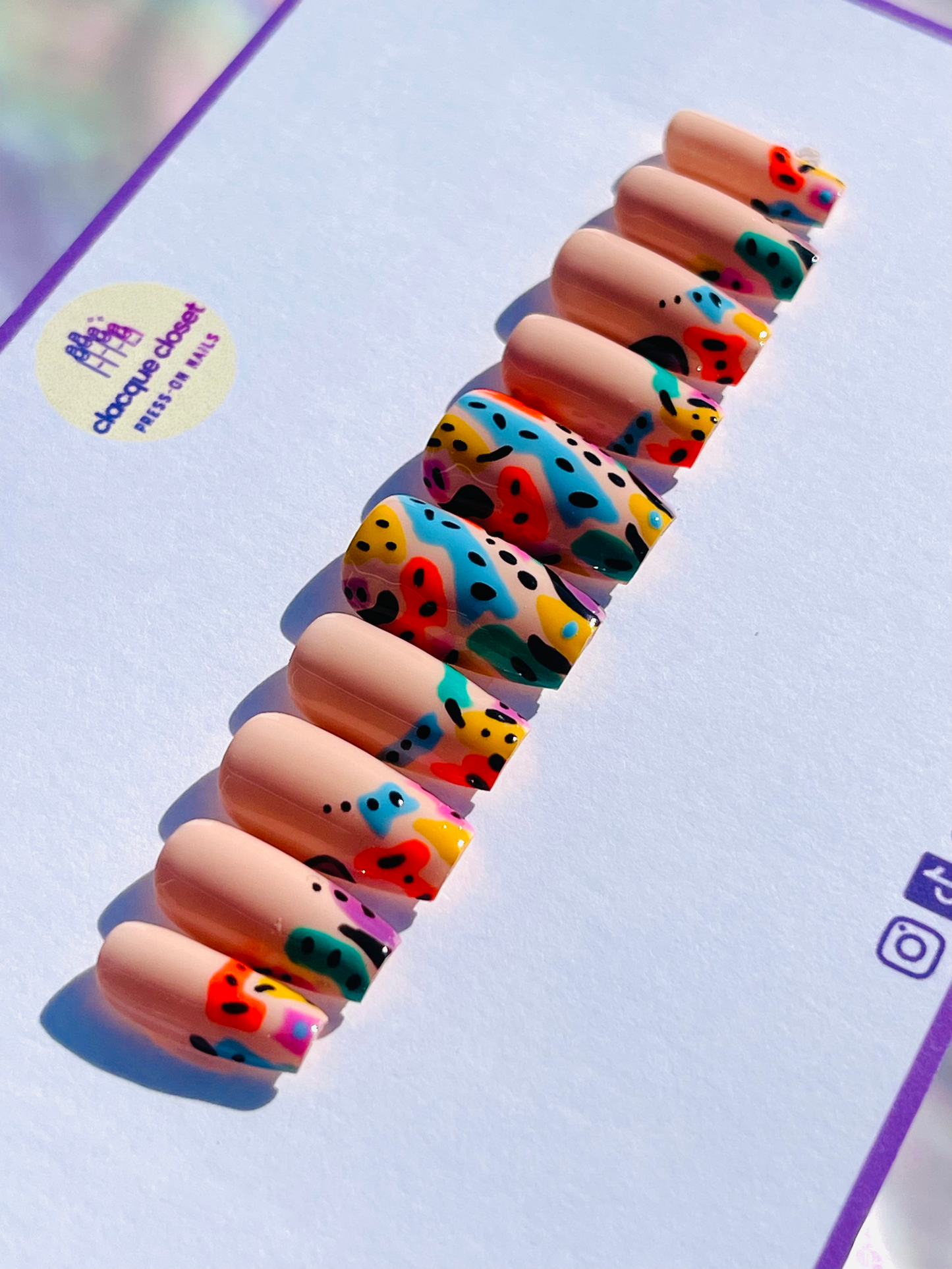 Coffin-shaped press-on nails featuring multi-colored line art for a vibrant and artistic design.