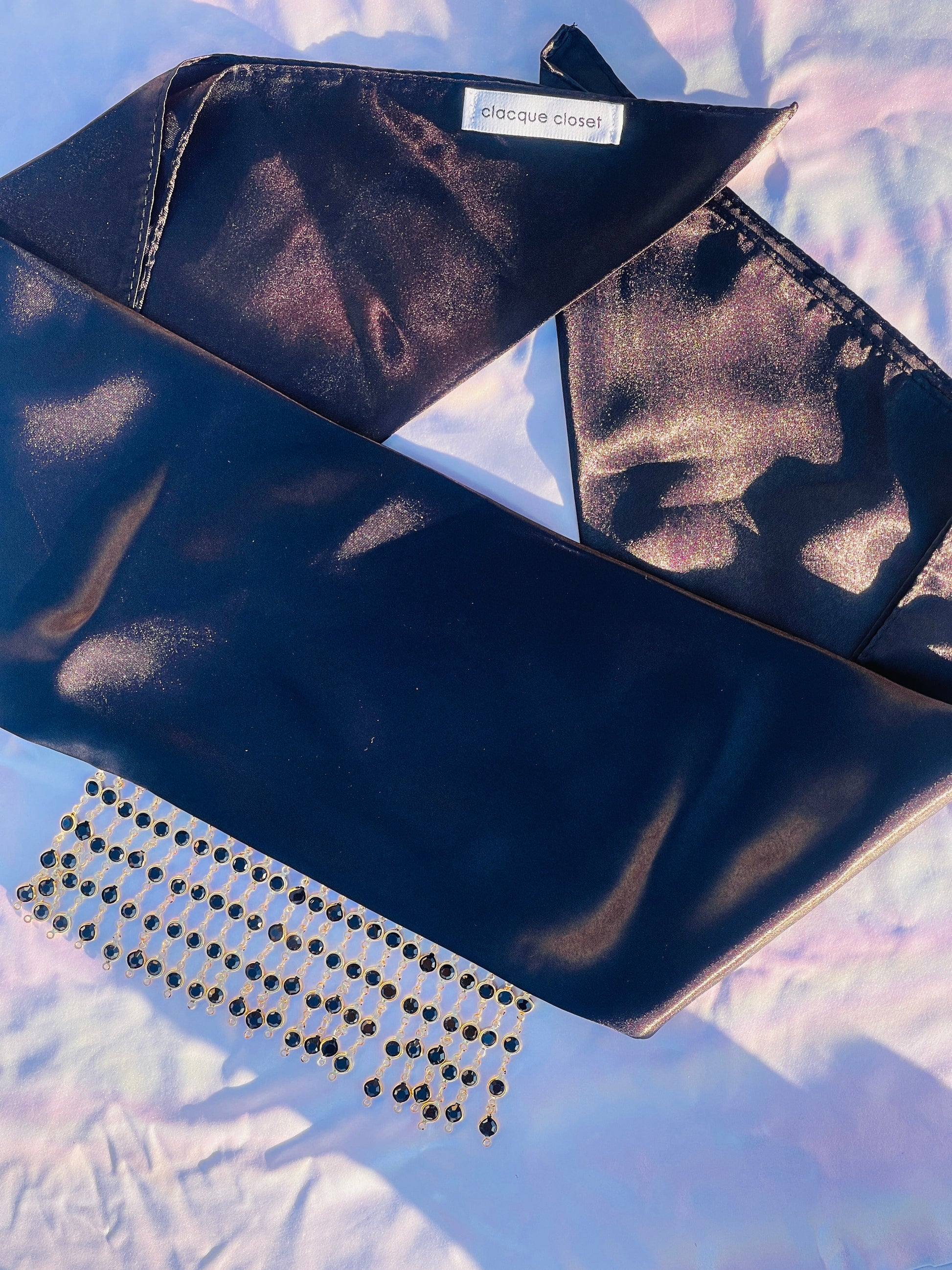 Close-up of the Kali black bandana bang with gold rhinestone fringe, lying flat.