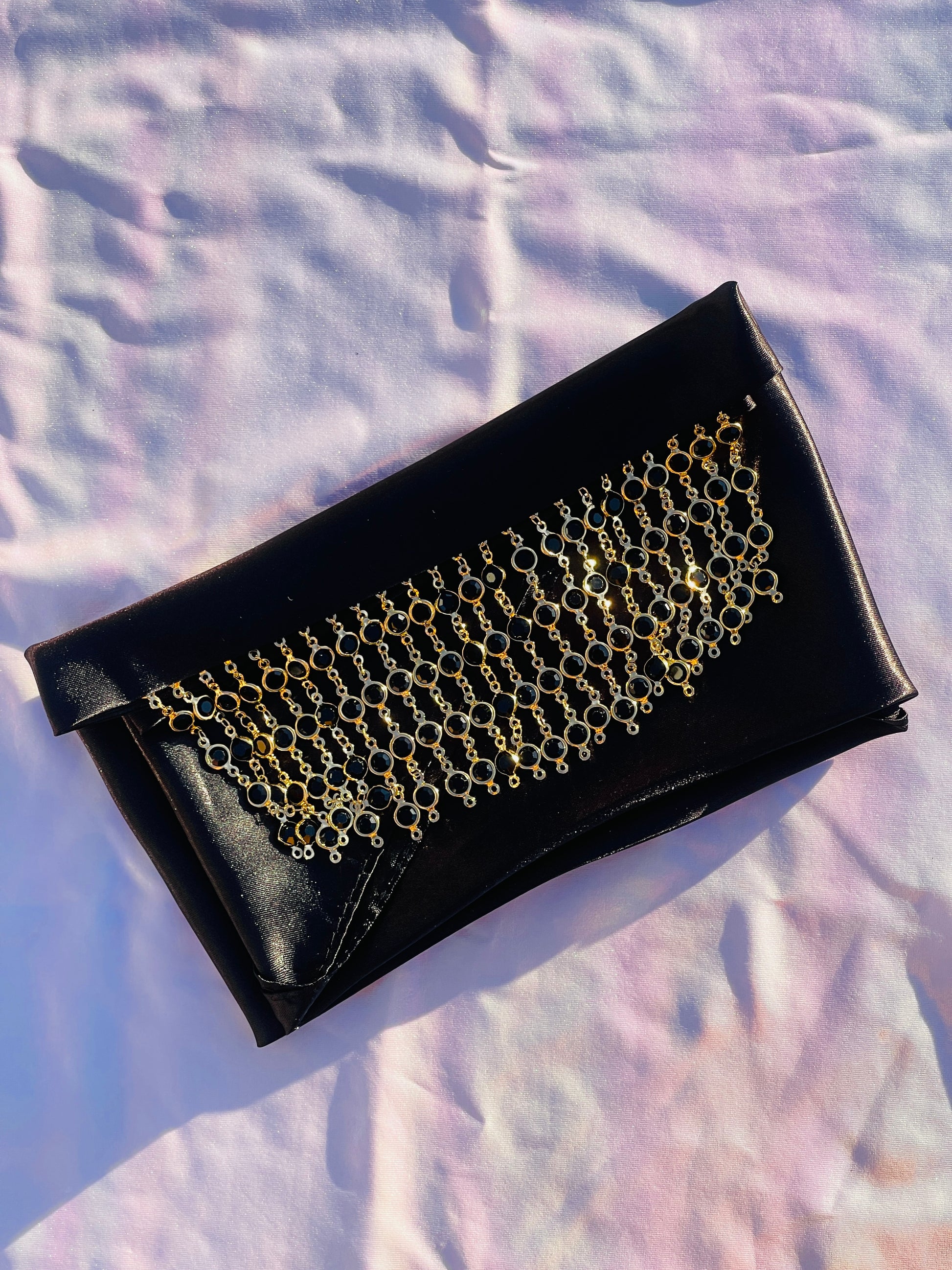 Close-up of the Kali black bandana bang with gold rhinestone fringe, lying flat.