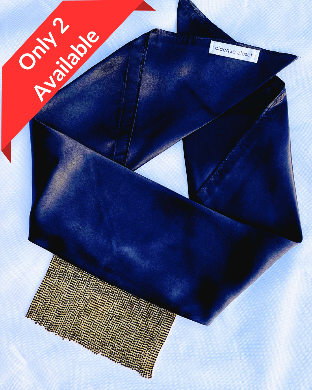 Minerva black satin bandana bang with gold fringe laid flat.