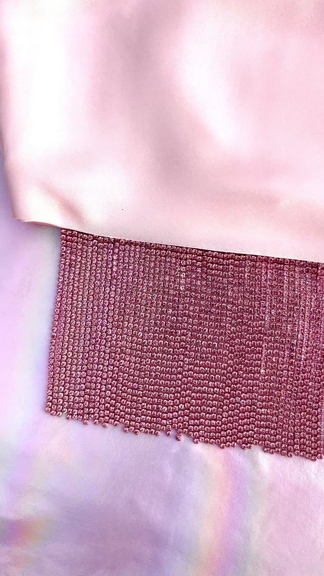 Video of Xochi handmade pink satin bandana bang with pink rhinestone fringe laid flat
